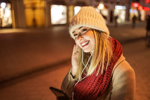 istock Smiling young woman using smart phone listening music 1367040118