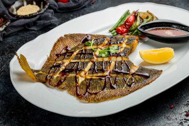 istock fried flounder on a plate with sauce on dark stone table 1367040460