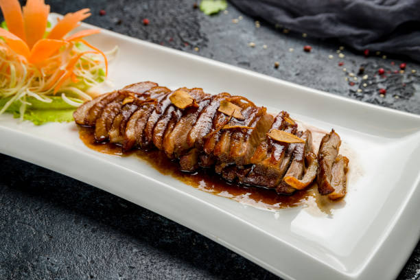 istock Peking duck on plate on dark stone table, Chinese cuisine 1367040571