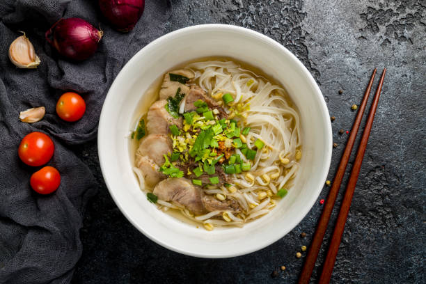 istock Soup Pho Bo with beef and noodles on white bowl on dark stone table top view 1367040643