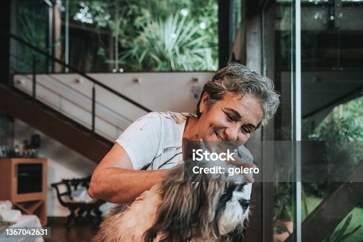 istock smiling senior woman stroking little dog 1367042631