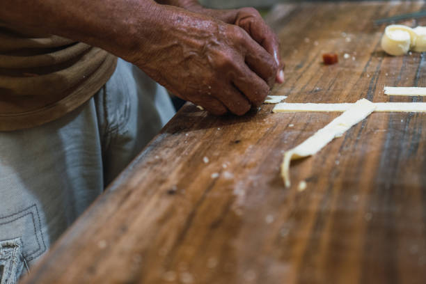 木製のテーブルの上でチーズを切る男の手 - cheese making ストックフォトと画像