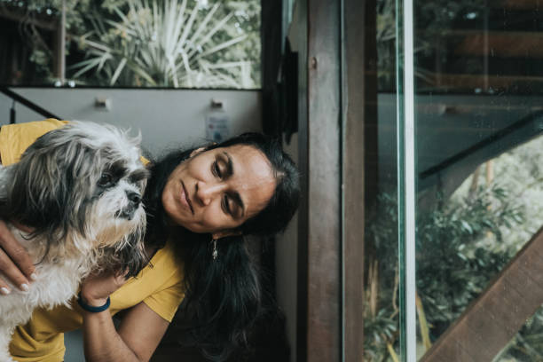 istock smiling woman stroking little dog 1367042827