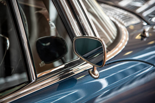 Side mirror of luxury classic car parked up in museum.