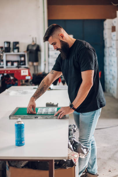 istock Male worker preparing screen printing film in workshop 1367048649