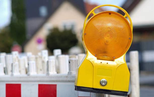 istock Construction site concept: construction site lamp hangs on one of numerous red and white barriers 1367053197