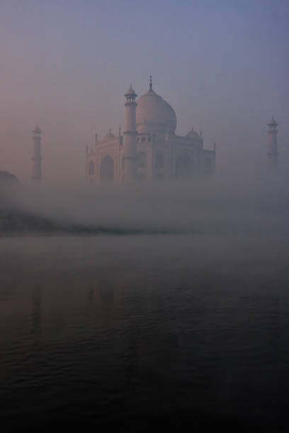 View of Taj Mahal reflected in Yamuna river with early morning fog, Agra, Uttar Pradesh, India stock photo