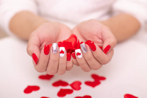 istock Female hands with red manicure nails, hearts design 1367054118