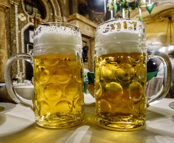 German beer Close-up image of two mugs of beer at a restaurant in Munich, Germany large german beer steins stock pictures, royalty-free photos & images