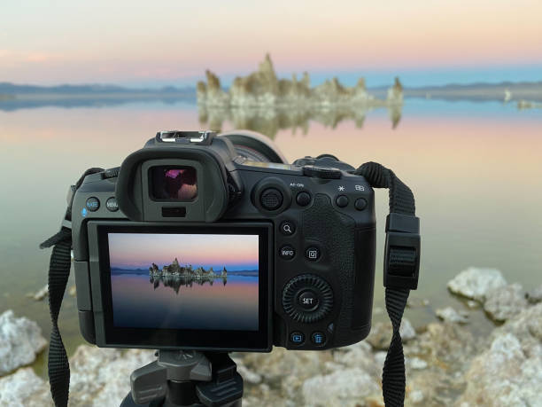 istock Professional, mirrorless, digital camera on a tripod with sunset landscape captured on the screen and in the distance. Mono Lake, California 1367063357