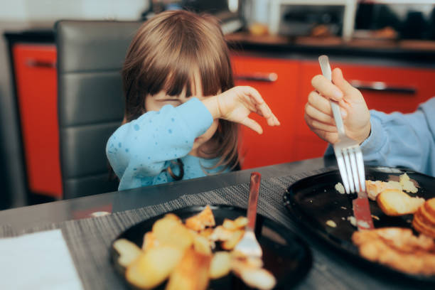 Toddler Girl Refusing to Eat Lunch at Home Little child rejecting hating bad boring food option for lunch food allergies stock pictures, royalty-free photos & images