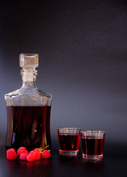 istock Raspberry liqueur, strong homemade alcohol and ripe red berries on a black background. 1367071418