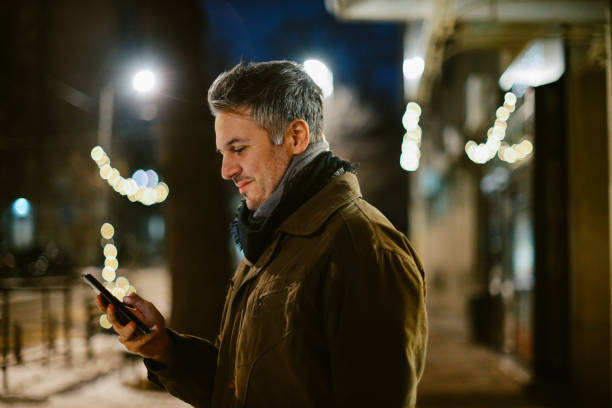 istock mid aged man checking his cellphone on the street 1367071492