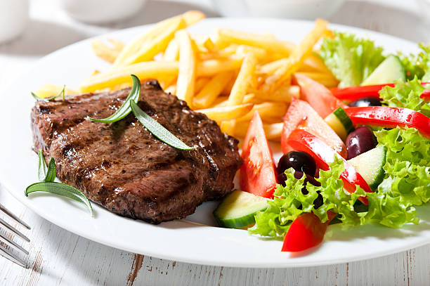 Grilled beefsteak with french fries and salad stock photo