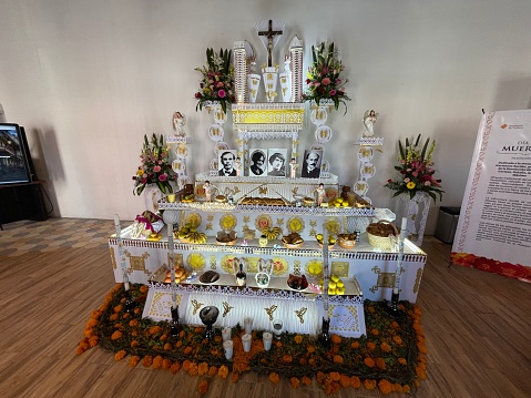 Traditional altar or offering of the dead, installed in the Tourist Information Module of the State of Puebla in the city of Puebla, on the occasion of the Day of the Dead 2021. The Day of the Dead is a typical celebration in much of the Mexican territory. The main day is November 2, on which the Catholic Church celebrates the feast of the faithful departed. This celebration in Mexico incorporates Christian traditions such as those dating back to pre-Columbian cultures that flourished in the region before the arrival of the Spanish. Part of the tradition is to erect these altars for the dead to honor deceased loved ones with the food, drinks and other details that they liked when they lived, as if they were coming back from the dead for that one time in the year to eat, drink and celebrate with the living.