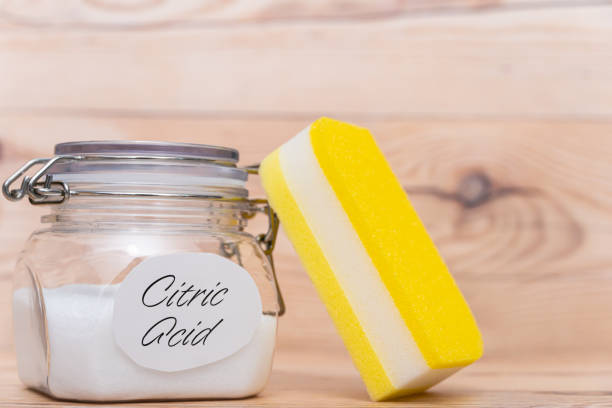 istock Citric acid in container on wooden background. 1367077544