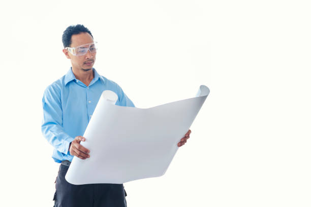 Construction engineer man hold blueprint wear blue shirt safety white hard hat at construction site industry labor worker. Architecture man engineer civil worker look at blueprint real estate concept