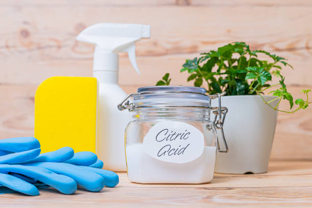 Citric acid in container and cleaning tools on wooden background. stock photo