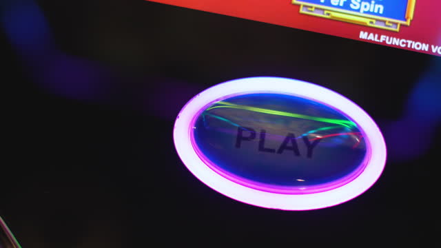 close up hand push play or spin button for gambling play slot machine in casino clubhouse
