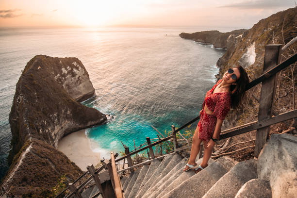 Beautiful girl on the background of Kelingking beach, Nusa Penida Indonesia. A young woman is traveling in Indonesia. Nusa Penida is one of the most famous tourist attraction place to visit in Bali stock photo