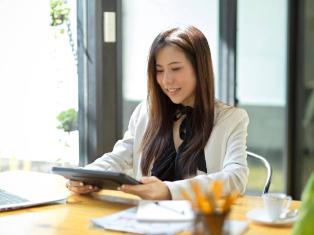 istock Woman using her digital tablet touchscreen while sitting in the office. 1367085612