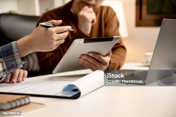 Young Business People Using Tablet Discussing The Future Structure Of The Company At Meeting Stock Photo - Download Image Now