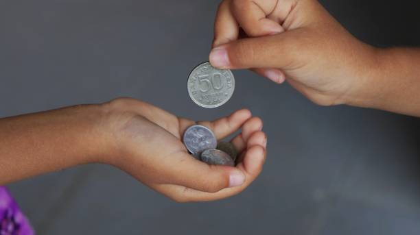ręczne wręczanie monety dziecku - alms zdjęcia i obrazy z banku zdjęć