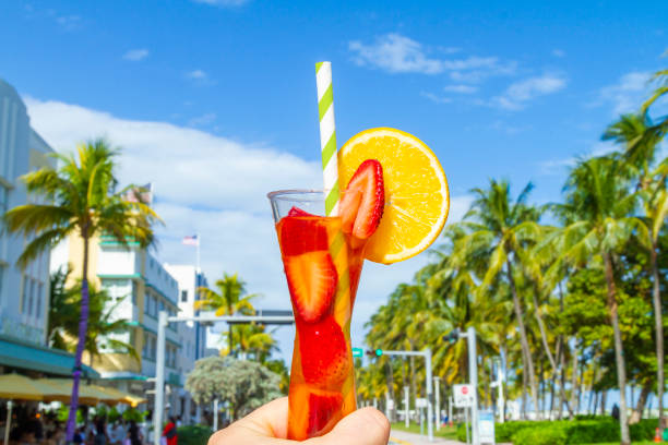 POV Point of view shot of a young travel male enjoying his vacations while drinking a cocktail in front of Ocean Drive, South Beach, Miami Beach, Miami, South Florida, United States of America POV Point of view shot of a young travel male enjoying his vacations while drinking a cocktail in front of Ocean Drive, South Beach, Miami Beach, Miami, South Florida, United States of America.
The picture is in the famous and touristic Art Deco District. Shooting from a personal perspective in an exotic tropical beach travel holidays.
Travel Concept. 1 hotel south beach stock pictures, royalty-free photos & images