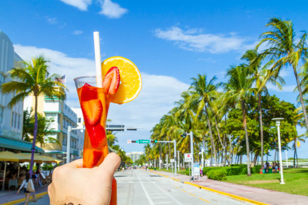 POV Point of view shot of a young travel male enjoying his vacations while drinking a cocktail in front of Ocean Drive, South Beach, Miami Beach, Miami, South Florida, United States of America POV Point of view shot of a young travel male enjoying his vacations while drinking a cocktail in front of Ocean Drive, South Beach, Miami Beach, Miami, South Florida, United States of America.
The picture is in the famous and touristic Art Deco District. Shooting from a personal perspective in an exotic tropical beach travel holidays.
Travel Concept. 1 hotel south beach stock pictures, royalty-free photos & images
