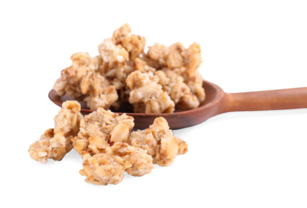 istock Tasty crispy granola and wooden spoon on white background 1367101832