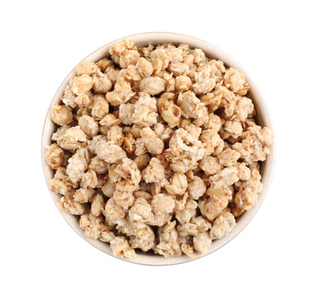 istock Tasty crispy granola in bowl isolated on white, top view 1367101833