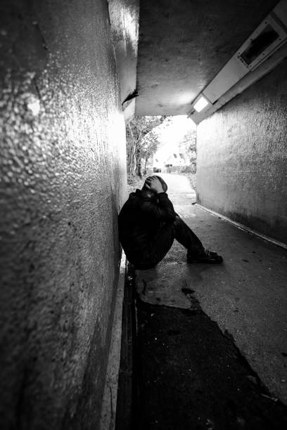 istock Homeless man sitting in cold dark subway tunnel 1367101950