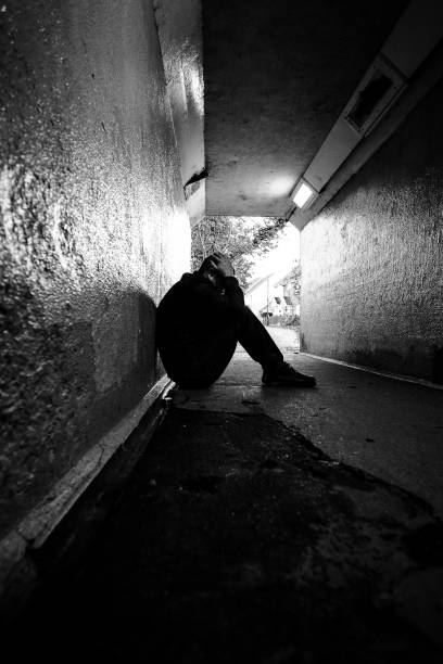 istock Homeless man sitting in cold dark subway tunnel 1367101952
