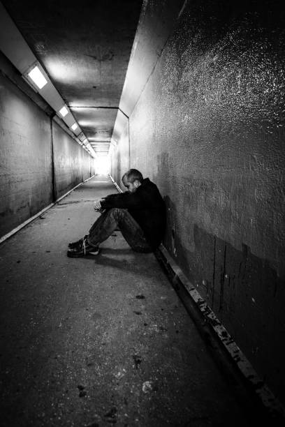 istock Homeless man sitting in cold dark subway tunnel 1367101953