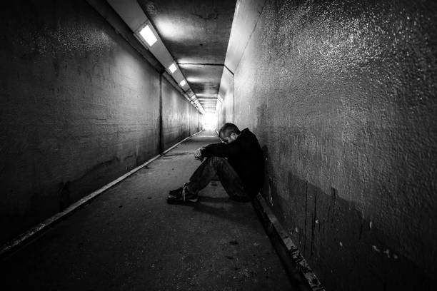 istock Homeless man sitting in cold dark subway tunnel 1367101963