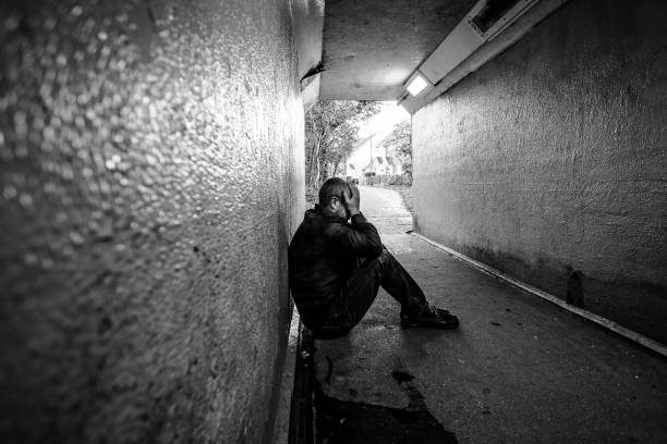 istock Homeless man sitting in cold dark subway tunnel 1367101967