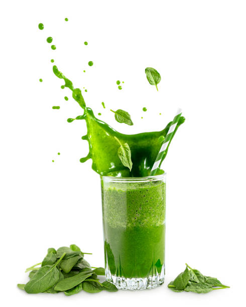 salpicando batido de espinacas verdes en vaso de bebida con hojas aisladas sobre fondo blanco - green drink fotografías e imágenes de stock