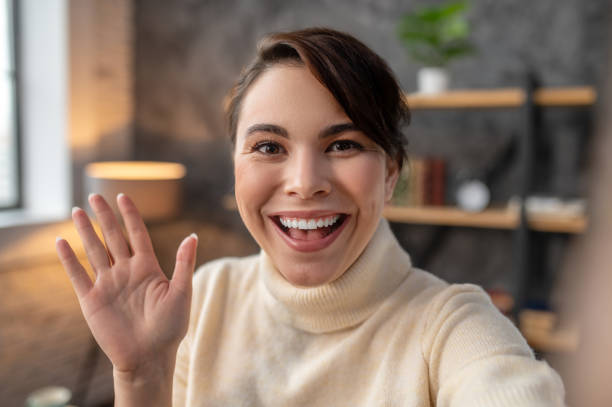 istock Happy young woman greeting someone via Skype 1367102988