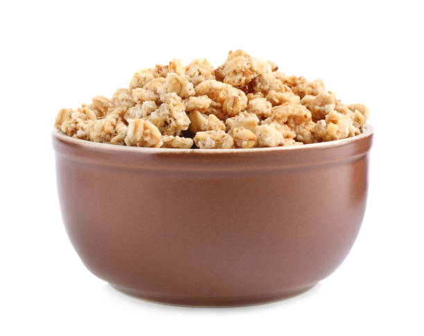 istock Tasty crispy granola in bowl isolated on white 1367103179