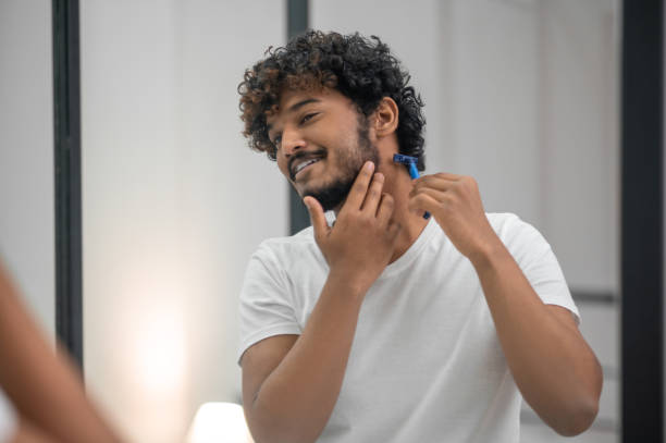 istock Smiling contented focused man looking at himself before shaving 1367104168