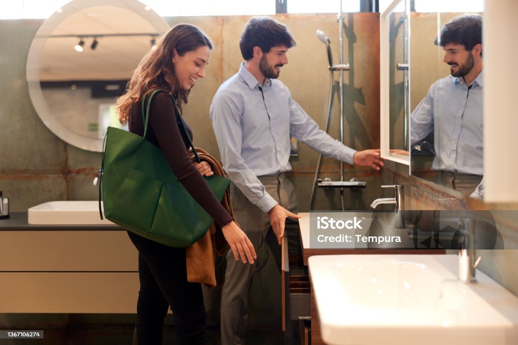 A couple is choosing a sink in a showroom. A couple is buying in a showroom. Bathroom Stock Photo
