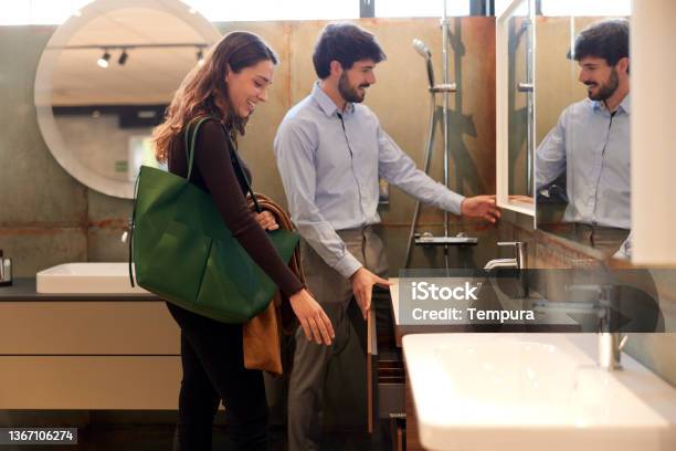 A Couple Is Choosing A Sink In A Showroom Stock Photo - Download Image Now - Bathroom, Renovation, Showroom