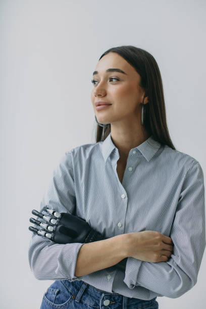 indoor-studio-porträt eines charmanten fotogenen weiblichen cyborgs mit künstlicher, hochentwickelter, bequemer armprothese anstelle der hand nach dem unfall. biotechnologie der zukunft. gesundheitswesen - prothese stock-fotos und bilder