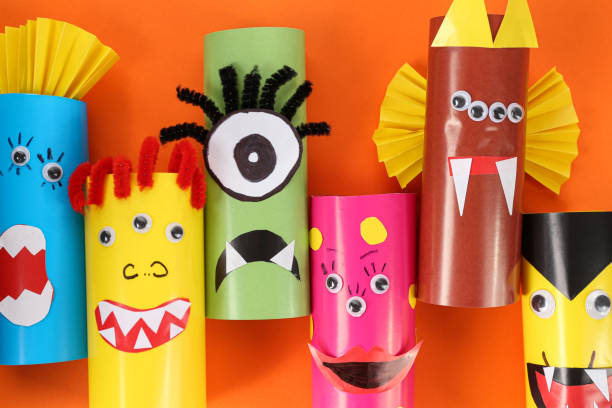 istock Funny monsters on orange background, flat lay. Halloween decoration 1367107523
