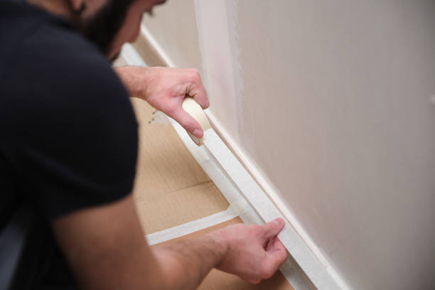 istock Unrecognizable painter using tape to cover the skirting board before painting. 1367107605