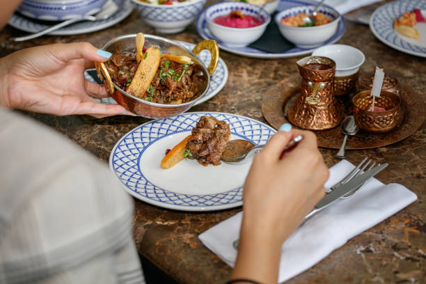 istock Pouring meat dish from bowl with spoon at the restaurant table 1367109029
