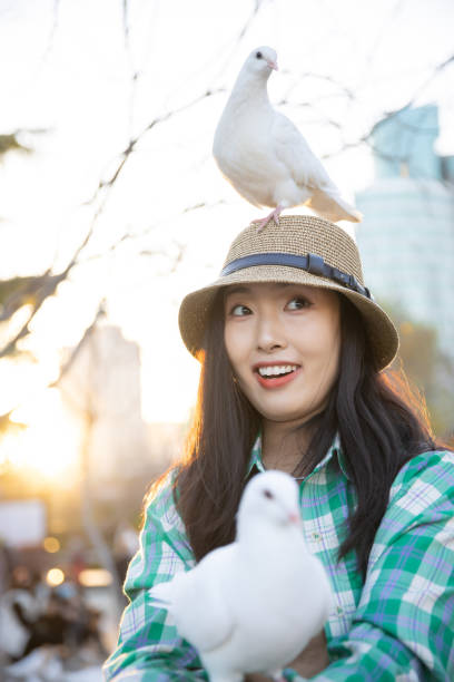 istock Pigeon standing on women head 1367109062
