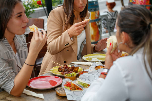 istock Young women eating Mexican food snacks in restaurant 1367112607