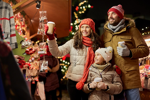 family with takeaway drinks at christmas market