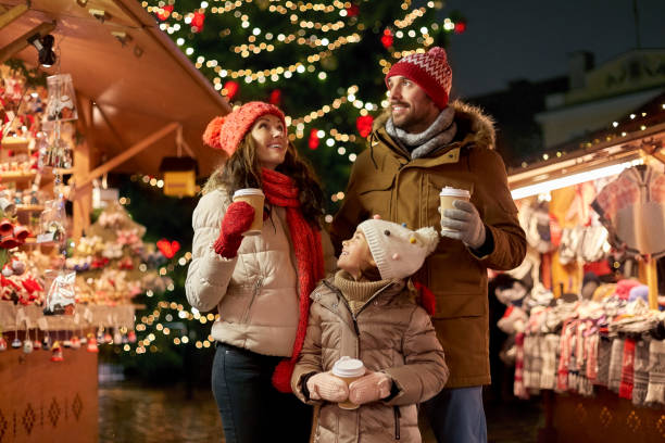 family with takeaway drinks at christmas market stock photo